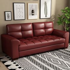 a living room with a red leather couch and pictures on the wall