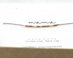 a bracelet with the word mama written on it in cursive writing and gold - plated beads