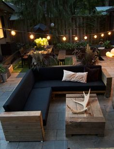 an outdoor seating area is lit up with string lights