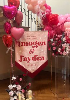 balloons and flowers are on display in front of a wedding sign