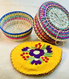 three woven baskets sitting next to each other on top of a white tablecloth covered floor