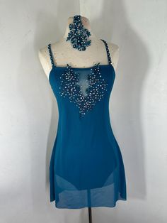 a mannequin wearing a blue dress with beads on it