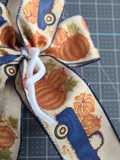 an orange and blue ribbon tied to a piece of cloth with pumpkins on it