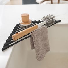 a brush, comb and glove are sitting on the edge of a bathtub