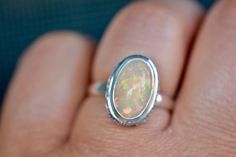 A beautiful big ethiopian opal of blue tones is set in a patterned bezel setting. The ring is made with sterling silver with a sturdy band suitable for regular wear. Can be resized for a fee. Size : US 7 Metal : Sterling Silver Gemstones : Ethiopian Opal Packaging : All products purchased from us come in a gift box. If you need to include a message, kindly leave us a note when purchasing. Care Recommendations: When not in use, keep earrings enclosed in a box or pouch to minimize exposure to mois Bohemian Oval Opal Ring, Spiritual Oval Opal Ring, Amethyst Wedding Rings, April Birthstone Ring, Amethyst Wedding, Natural Opal Ring, Ethiopian Opal Ring, Minimalist Earrings Studs, Fire Opal Ring