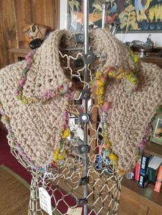 a knitted scarf is on display in a room with other items and bookshelves