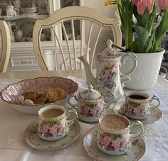 a table topped with cups and saucers filled with food