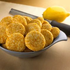 a bowl filled with cut up cookies next to a lemon