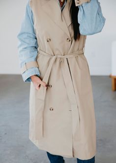 Layered look trench coat with denim jacket lining. Laurie is wearing a size small. Measurements: Body Length: 47" | Sleeve Length: 22" Small: Bust: 44" Waist: 42" Arm: 19" Medium: Bust: 45" Waist: 44" Arm: 19" Large: Bust: 46" Waist: 47" Arm: 20" Self: 66% Rayon 34% Polyester Contrast: 100% Rayon Belted Beige Cotton Outerwear, Spring Collared Outerwear For Everyday, Spring Collared Belted Outerwear, Spring Belted Button-up Outerwear, Spring Double-breasted Gabardine Outerwear, Spring Workwear Outerwear: Long Coat, Classic Spring Outerwear For Layering, Classic Spring Layering Outerwear, Chic Cotton Outerwear For Layering