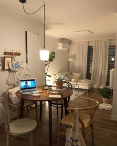 a living room filled with furniture and a laptop computer on top of a wooden table