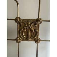 an ornately designed metal headboard against a white wall