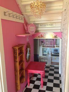 a pink table in the middle of a room with black and white checkered floor