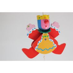 a toy with a clown on it's head is hanging from a hook in the shape of a bird