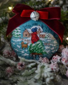 a christmas ornament with a red bow on it's head and an image of a woman riding a sleigh