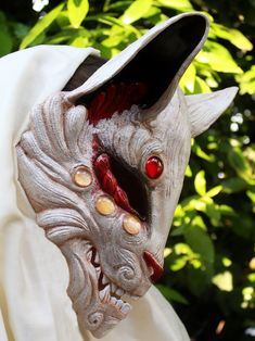 a close up of a mask with red eyes