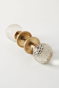 two glass door knobs on a white surface