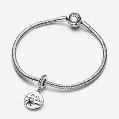 Meet the Mama Engravable Dangle Charm – a sterling silver piece that celebrates motherhood with a hint of humor. This Pandora charm features a round disc engraved with the words "Don't mess with Mama." The charm's unique touch lies in the enamel-filled 'Mama,' adding a pop of black. The bail is adorned with raised hearts and lines. What makes it extra special? The reverse side is ready for your personal touch with a personalised engraving to make it even more unique. Gift it as a special token for your mom for a playful tribute to the joy of motherhood. - Pandora Mama Engravable Dangle Charm - Enamel / Sterling silver / Black Sterling Silver Round Charms For Mother's Day, Everyday Silver Charms For Mother's Day, Sterling Silver Round Disc Jewelry For Mother's Day, Silver Round Charms For Personalized Gifts, Silver Engraved Charms For Mother's Day, Engraved Silver Charms For Mother's Day, Mother's Day Engraved Silver Charms, Adjustable Engraved Sterling Silver Charms, Custom Charm Bracelet