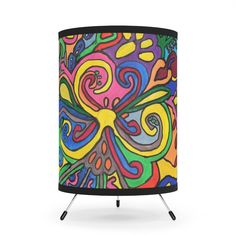 a colorful lamp shade with an abstract design on the front and bottom, sitting on a stand