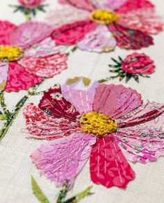 pink and yellow flowers on white fabric with green stems in the center, closeup