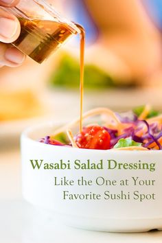 a person pouring dressing into a bowl filled with vegetables