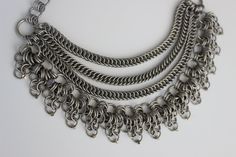 I made this Stainless Steel Collar Chain using a mix of Half Persian + European weaves stacked together, creating this striking, size adjustable, tiered collar. The intricate patterns of chainmail create a distinctive, textured look that stands out and commands attention.  Each piece involves linking numerous small rings together in a precise pattern. This meticulous process requires careful attention to detail. Since I make each piece by hand, this labor-intensive process can be time-consuming. Bohemian Chainmail Metal Jewelry, Diy Chainmail, Chainmail Choker, Chainmail Patterns, Steel Collar, Stainless Steel Collar, Chainmail Necklace, Collar Chain, Studded Jacket