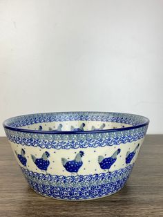 a blue and white bowl sitting on top of a wooden table