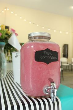 a pink beverage in a jar sitting on top of a table