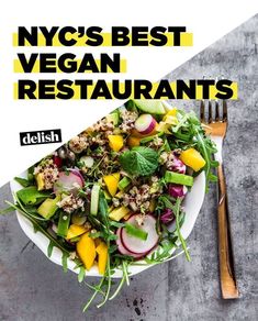 a white plate topped with salad next to a fork