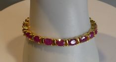 Elevate your jewellery collection with this stunning Fine Solid Silver 18ct Gold Plated Real Ruby Line Tennis Bracelet. Crafted with 925 Metal Purity and featuring an exquisite Ruby Stone, this Bracelet is perfect for adding a touch of glamour to any outfit. The timeless design of this Tennis Bracelet is versatile and suitable for any occasion, making it a must-have piece for any jewellery lover. The Line style of this Bracelet adds a delicate touch, while the Fine Silver and 18ct Gold combinati Exquisite Hallmarked Bracelets For Formal Occasions, Exquisite Hallmarked Bracelet For Formal Occasions, Classic Hallmarked Tennis Bracelet For Formal Occasions, Classic Ruby Tennis Bracelet For Formal Occasions, Classic Formal Hallmarked Tennis Bracelet, Yellow Gold Ruby Tennis Bracelet For Anniversary, Ruby Tennis Bracelet In Yellow Gold For Anniversary, Round Ruby Bracelet For Formal Occasions, Anniversary Ruby Tennis Bracelet In Yellow Gold