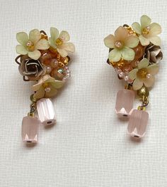 VINTAGE Colleen Toland Pink Dangle Flower Earrings.  Soft Pink with Soft Mint Green Rose Flower Earrings handbeaded with handpainted resin flowers and leaves with pretty satin glass barrel beads as drops. The works shown are the last pieces from Colleen's archive.  They are no longer in production and will not be remade.  They are not pre-owned and have never been worn.  They come with a certificate of authenticity that catalogs the piece and guarantees that it is a genuine Colleen Toland work of art. A bit about Colleen.   Colleen Toland has been making jewelry since the mid 1980s.  Although her style has changed through the decades, she is predominately known for a signature style that is romantic and feminine.  Her abilities as a colorist are appreciated and admired by many of her conte Vintage Wedding Jewelry With Dangling Beads, Vintage Handmade Clip-on Earrings For Party, Handmade Vintage Clip-on Earrings For Party, Vintage Handmade Pink Flower Earrings, Vintage Handmade Earrings For Wedding, Vintage Gold Beaded Earrings, Handmade Vintage Pink Flower Earrings, Pink Handmade Vintage Flower Earrings, Handmade Pink Vintage Flower Earrings