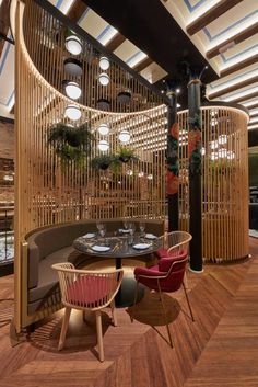 a restaurant with round tables and chairs in front of a circular wooden screen divider