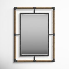 a mirror that is on the wall with some kind of rope around it and an iron frame