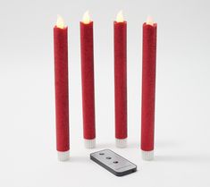 three red candles are next to a remote control