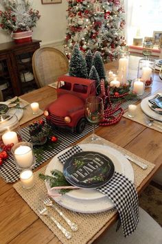 a table set for christmas with plates and candles