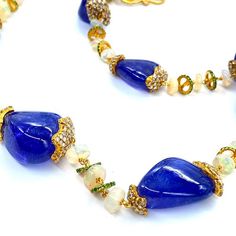 Affinity 20 Karat Yellow Gold Necklace Set with Tanzanite Beads, Opal Beads, and Diamonds. The Necklace Comes With A Lobster Clasp. All Of Our Items Are Handmade. We Believe in Craftsmanship and Originality. 17.39cts diamonds 42.93cts opal 306.97cts tanzanite 20K yellow gold Length: 32 inches The Affinity Collection is a myriad patchwork of cultures, each woven together by a natural attraction to the vibrant, mysterious, and beautiful force emanating from them. The harmonious combination of tumb Elegant Blue Beaded Necklace With Gemstone Accents, Elegant Blue Beaded Necklaces With Gemstone Accents, Gold Gemstone Beaded Necklace For Formal Occasions, Formal Gold Gemstone Beaded Necklace, Formal Beaded Briolette Necklace, Elegant Gold Gemstone Beads And Cabochons, Elegant Gold Gemstone Beads, Elegant Gold Beaded Necklace With Gemstone Accents, Elegant Beaded Necklace With Gemstone Accents