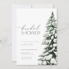 the snow covered pine tree bridal shower card is displayed on a marble table top