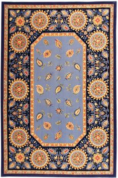 a blue rug with an ornate border and floral designs on the bottom, in various colors