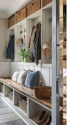 the inside of a room with many coats hanging on the wall and shoes in baskets