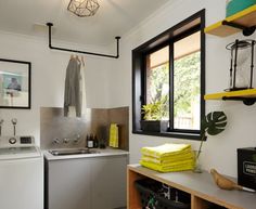 a kitchen with a washer and dryer next to a window in the wall