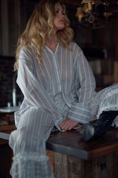 Airy and unrestrained, this relaxed fit cotton gauze blouse stands out with classic design details–an elegant back pleat, fabric covered buttons, wide cuffs, and a gold hardware detail at the back. Perfect for sipping sarsaparilla on the porch or layering over your chemise for a moonlit ride across the open range. Style with the Ivory Duchess Corset and Lake Stripe Pantalettes to complete the look. Cotton gauze button up shirt Relaxed fit Long sleeves Fabric covered buttons Gold hardware Selkie Classic Long Sleeve Blouse For Loungewear, Summer Loungewear Blouse With Button Cuffs, Classic Tops With Smocked Cuffs For Daywear, Relaxed Fit Tops With Smocked Cuffs For Daywear, Summer Loungewear Tops With Button Cuffs, Summer Tops With Button Cuffs, Classic Spring Blouse For Loungewear, Chic Loungewear Blouse With Button Cuffs, Chic Blouse With Buttons For Loungewear