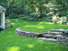 a small white house sitting in the middle of a lush green yard