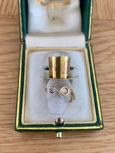 The Pendant consists of a carved rock crystal skull which has a gold top hat. The dimensions of the pendant are 28mm by 12mm and is housed in its own fitted box. The pendant has a bale that folds down. Set in the eyes of the skull are two bright white diamonds that have been set in rub over settings and weight intotal approximately 0.50ct. The pendant tests as 18ct yellow gold. The piece is totally unique and looks totally stunning when worn. Skull With Top Hat, Georgian Ring, Ceylon Blue Sapphire, Rosecut Diamond Ring, Diamond Eyes, Eye Pendant, Gold Top, Crystal Skull, Rock Crystal