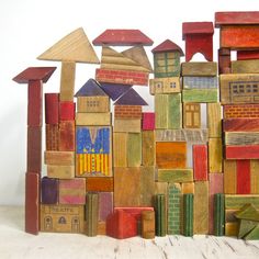 colorful wooden blocks stacked on top of each other in front of a white wall and floor