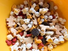 a yellow bowl filled with lots of different types of snacks and treats on top of each other