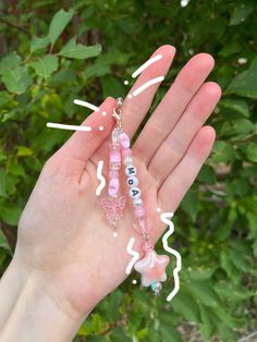 a person holding some pink beads in their hand with green leaves behind them and the words doula written on it