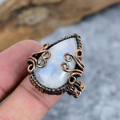 Discover the elegance of our Natural Rainbow Moonstone Gemstone Handmade Copper Wire Wrapped Ring. This exquisite piece of jewelry is handcrafted with care, featuring a stunning rainbow moonstone gemstone encased in intricately wrapped copper wire. Each ring is unique, boasting a beautiful blend of natural iridescence and rustic charm. Perfect for size 10, this ring makes a thoughtful gift or a stylish addition to your jewelry collection. Enjoy the timeless beauty and healing properties of moons Elegant Adjustable Moonstone Ring For Healing, Handmade Adjustable Moonstone Ring, Handmade Adjustable Unique Moonstone Ring, Unique Handmade Adjustable Moonstone Ring, Bohemian Wire Wrapped Jewelry For Anniversary, Spiritual Moonstone Ring Jewelry, Unique Hand Wrapped Jewelry For Anniversary, Hand Wrapped Spiritual Jewelry For Anniversary, Spiritual Hand Wrapped Jewelry For Anniversary