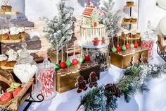 an assortment of desserts and candies on display in front of a christmas scene