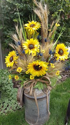 a bucket filled with sunflowers and grass next to a dog on the ground