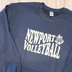 a blue sweatshirt with the words newport volleyball printed in white on it's chest