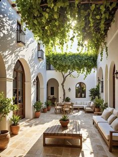 an outdoor patio with seating and potted plants on either side of the building, surrounded by greenery